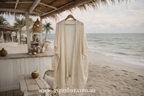 Beige cardigan on a hanger with a beach and ocean view in the background