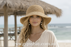 Woman wearing a straw hat with a blurred beach background