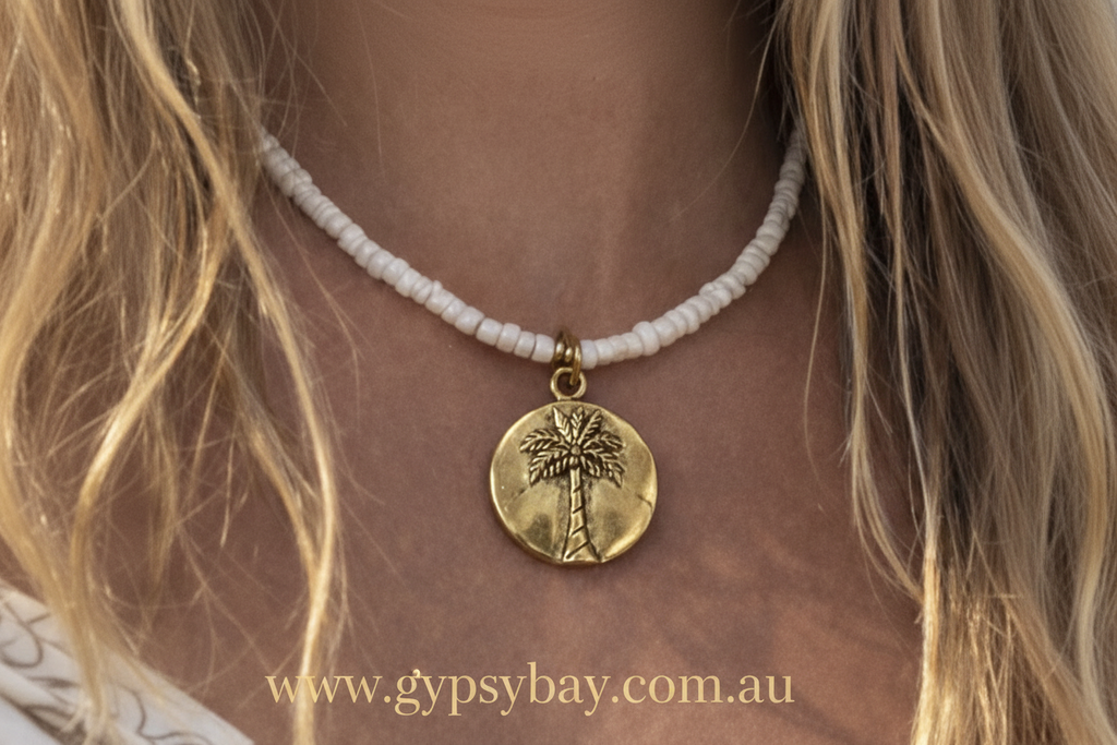 Necklace with a palm tree pendant worn by a person