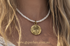 Necklace with a palm tree pendant worn by a person
